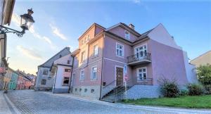 克拉利基Vila Nikola Králiky的城市街道上一座粉红色的大房子