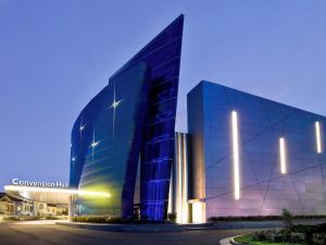 邦加槟港邦加岛诺富特酒店及会议中心的一座在晚上拥有蓝色外墙的大型玻璃建筑