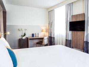 雷恩诺富特SPA雷恩中心火车站酒店的配有一张床和一张书桌的酒店客房