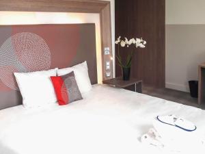 雷恩诺富特SPA雷恩中心火车站酒店的一间卧室配有一张大床和两个枕头