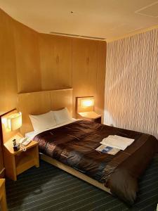 岐阜韦尔吉赞大酒店的酒店客房设有一张大床和两盏灯。