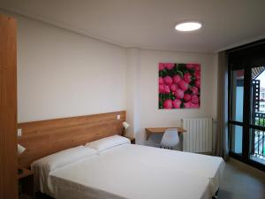 诺哈Apartamentos Gran Socaire de Noja的卧室配有白色的床和苹果画