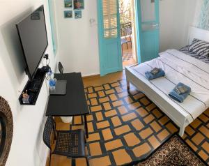 海法GuestHouse COMFY - separate rooms in the apartment for a relaxing holiday的一间卧室配有一张床和一张带笔记本电脑的桌子