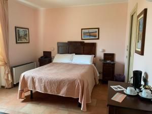 Castellinaldo蒙格里托酒店的一间卧室配有一张大床和一张桌子