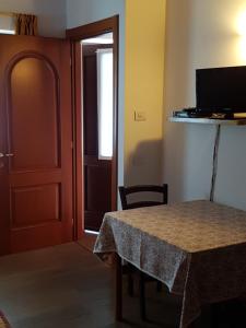 PilaDa Petro Appartamenti per vacanze的一间设有桌子、门和电视的房间