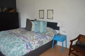 艾森斯塔特博克斯58公寓 的一间卧室配有一张带蓝色床头柜和一张桌子的床