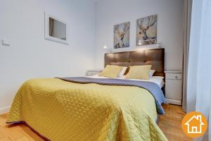 米兹多洛杰Apartamenty Aquamarina - visitopl的一间卧室配有一张带黄色毯子的大床
