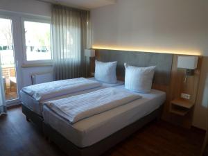 林根Hotel - Restaurant Veldscholten的一间卧室设有两张床和大窗户