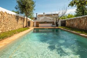 图内什Villa Monte Algarvio - Private Heated Pool - wifi的石头墙前的游泳池