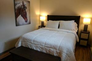 威尔森Spectacular Mountain Condo的卧室配有一张大床,墙上挂有马术照片