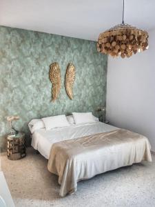 塞维利亚El Patio de San Bernardo的卧室配有一张大床,墙上挂着天使翼