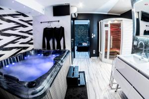 勒米尔蒙Appart Hotel GLAM88 Suites avec SPA et Sauna Privatif的带浴缸和盥洗盆的浴室