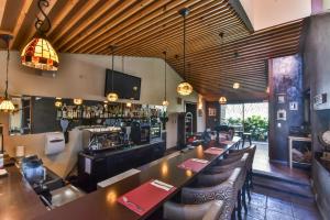 San Antonio里维埃拉酒店的餐厅设有酒吧,配有桌椅
