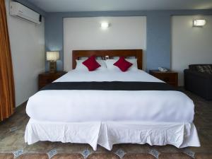 伊拉普阿托Suites de Reyes的卧室配有带红色枕头的大型白色床