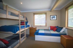 丁诺高原Colorado的一间卧室配有两张双层床,提供蓝色和红色枕头
