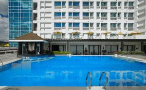 宿务Quest Hotel & Conference Center Cebu的大楼前的大型蓝色游泳池
