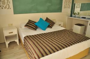 锡德Aura Boutique Hotel的一间卧室配有一张带蓝色枕头的大床