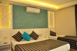 锡德Aura Boutique Hotel的酒店客房设有两张床和绿色的墙壁。