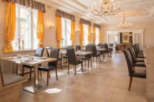 多瑙河畔克雷姆斯菩提树大道酒店的一间带桌椅和吊灯的餐厅
