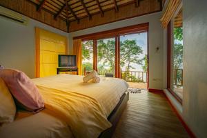 象岛沙艳贝的一间卧室设有一张大床和一个大窗户