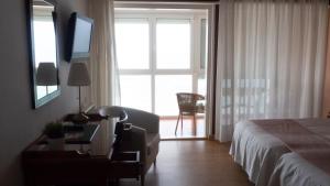 柯米拉斯Hotel Josein的一间卧室配有一张床、一张书桌和一个窗户。