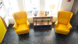 柯米拉斯Hotel Josein的两个黄色的椅子和一张桌子