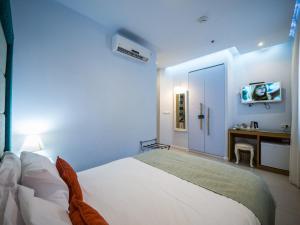 海法贝特咖里姆精品酒店的一间卧室配有一张床、一张书桌和一台电视