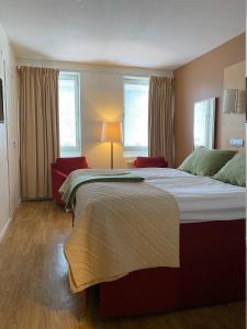 恩舍尔兹维克斯特兰德城市酒店的一间卧室设有两张床和一盏灯,配有窗户。