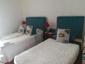 波尔图Hotel Cristo Rei的一间卧室配有两张带蓝色床头板的床。