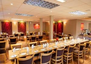 吉林汉姆查尔斯国王酒店的大型用餐室配有桌椅