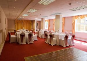吉林汉姆查尔斯国王酒店的宴会厅配有桌椅和白色的桌布