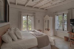 科洛尼亚-德尔萨克拉门托沙尔科酒店的白色卧室设有一张大床和两个窗户