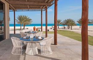达沙 萨巴尼亚岛奥亚姆安纳塔拉别墅度假酒店的一个带桌椅的庭院和海滩