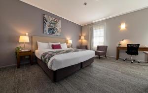 华威华威考迟曼斯汽车旅馆的酒店客房设有一张大床和一张书桌。