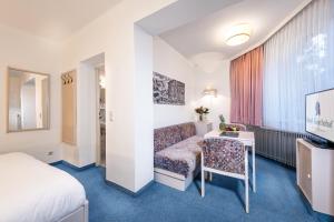 巴德加斯坦Hotel Goethehof的配有一张床和一张书桌的酒店客房