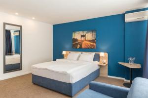 贝尔格莱德Premium Crown Suites的一间卧室设有一张床和蓝色的墙壁