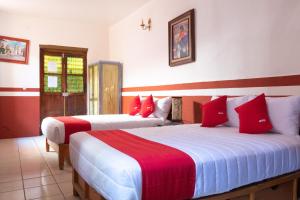 萨卡特卡斯OYO Hotel Meson de la Concepcion的红色和白色的客房内的两张床