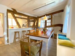 蒙绍Monschau-Auszeit: Historisch wohnen direkt am Bach的厨房以及带木桌和椅子的用餐室。