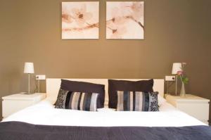 巴塞罗那巴塞罗那旅客酒店的一间卧室配有一张带2个床头柜的大型白色床