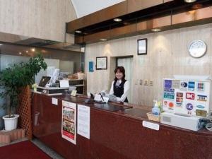 川崎Sky Heart Hotel Kawasaki / Vacation STAY 80810的坐在餐厅柜台的女人