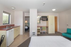 新普利茅斯贝拉维斯特汽车旅馆的一间卧室配有一张床,厨房配有水槽