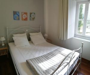 伊兹拉Pine Trees and Sea View Houses in Hydra - Daphne, Chloe, Myrto, Eleni的卧室内的一张带白色床单和枕头的床