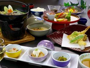 十日町Nomoto Ryokan Matsunoyama Onsen的餐桌,盘子上放着食物和碗