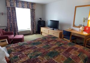 罗斯维尔Norwood Inn and Suites - Minneapolis-St Paul Roseville的酒店客房,配有床和电视