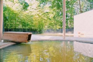 北斗市HOTEL KEYFOREST HOKUTO的庭院里一个带木制浴缸的水池