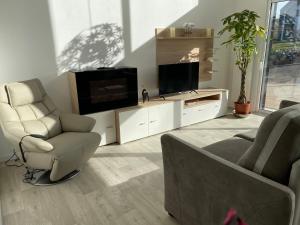 Fresnicourt-le-DolmenLa Cooconing的客厅配有电视、沙发和椅子