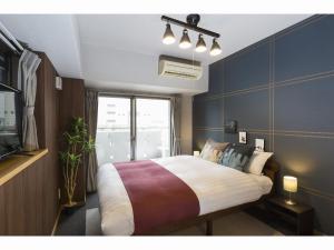 长崎Coruscant Hotel Nagasakieki的一间卧室设有一张大床和一个窗户。