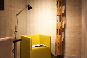 埃森考斯晨艺术酒店的房间里的一张黄色椅子和一盏灯