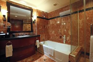 马尼拉Diamond Hotel Philippines的带浴缸和盥洗盆的浴室