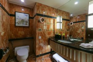 马尼拉Diamond Hotel Philippines的一间带卫生间、水槽和镜子的浴室